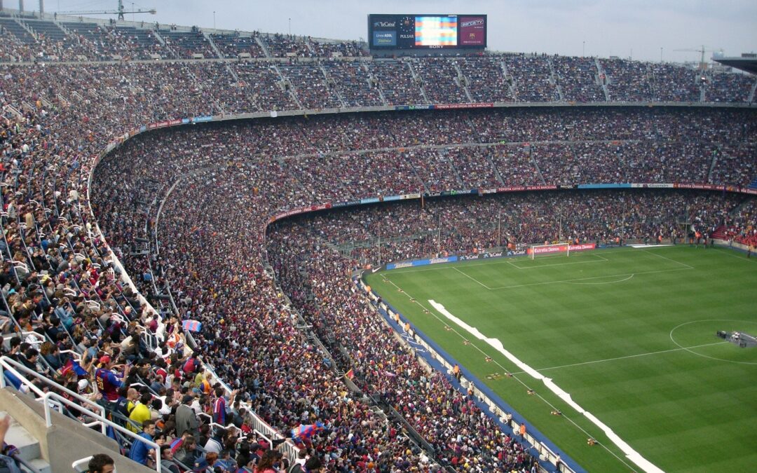 Estádio de futebol em dia de torneio lotado de torcedores.