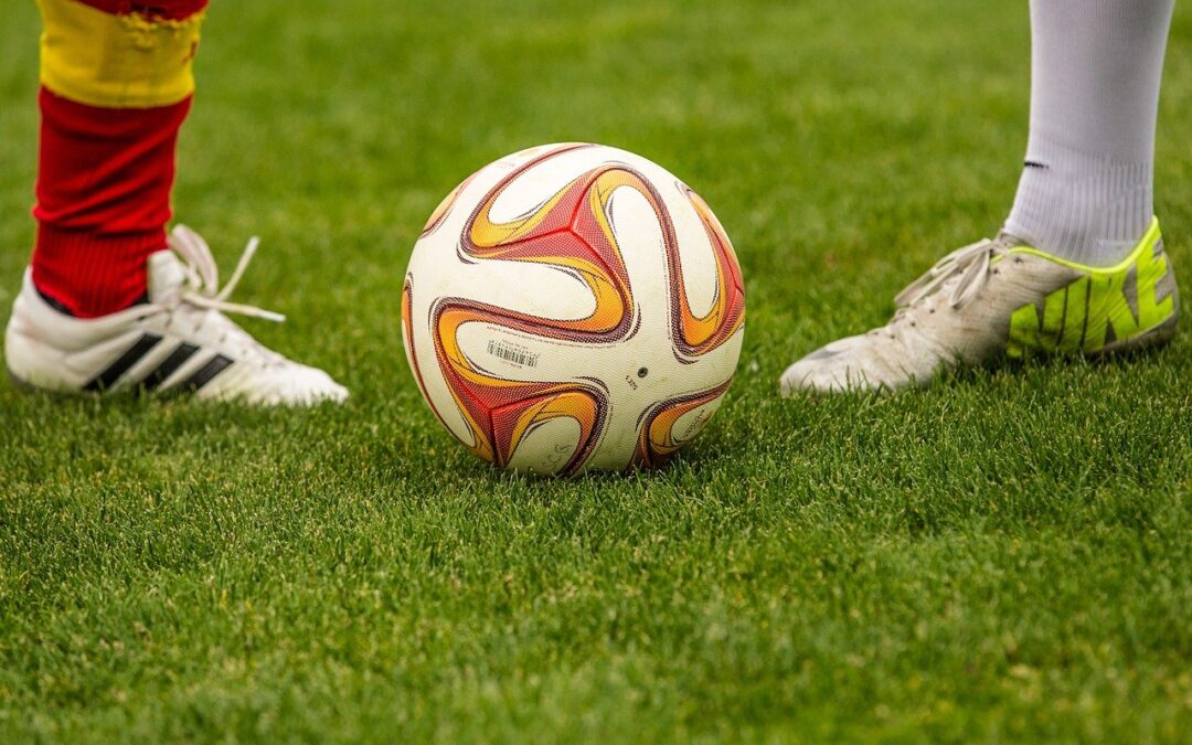 imagem ampliada dos pés de dois jogadores perto de uma bola de futebol