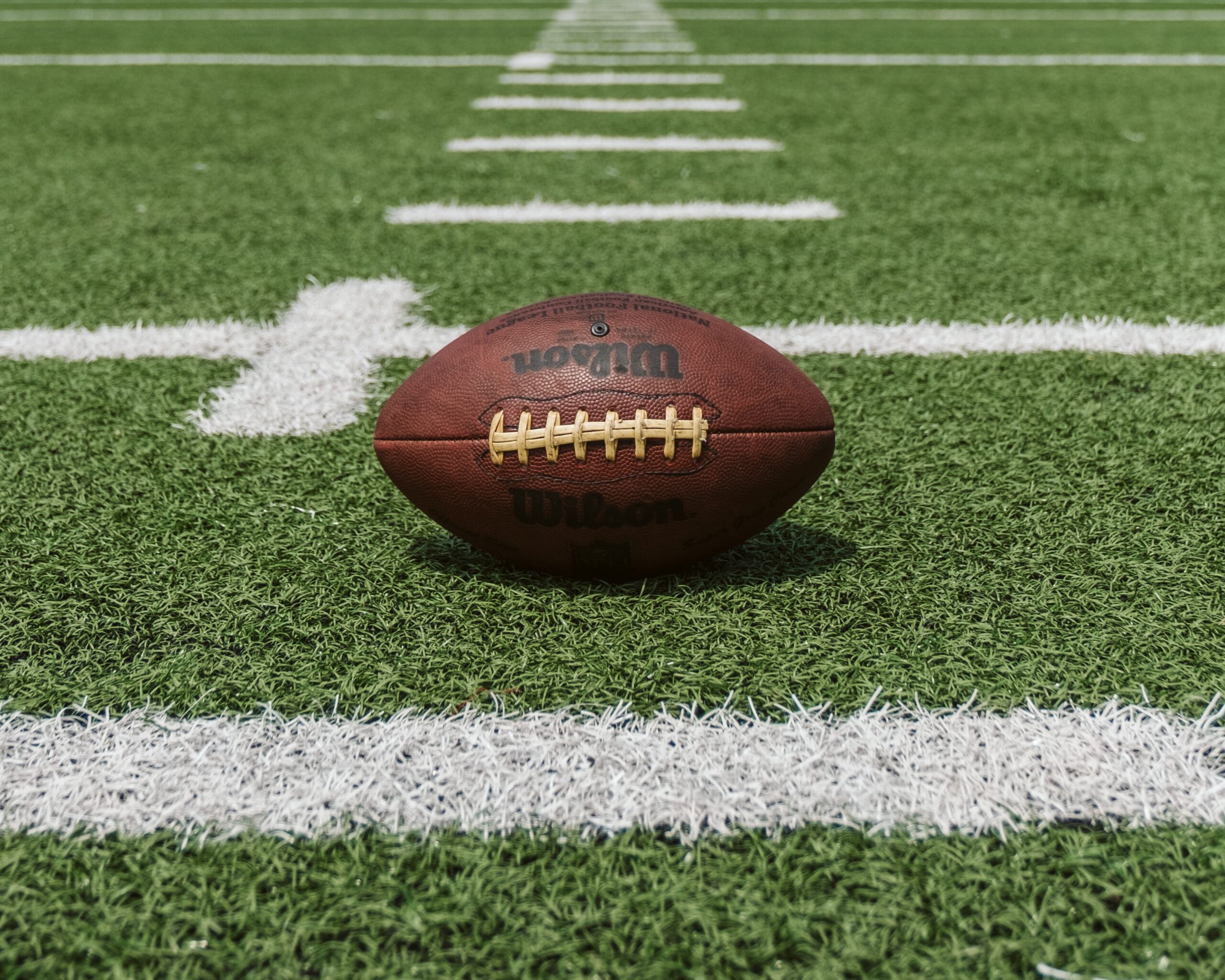 uma bola de futebol americano no meio do campo: como apostar na NFL